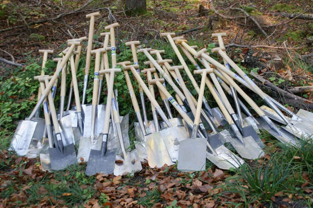 veel scheppen liggen op een hoop in het bos