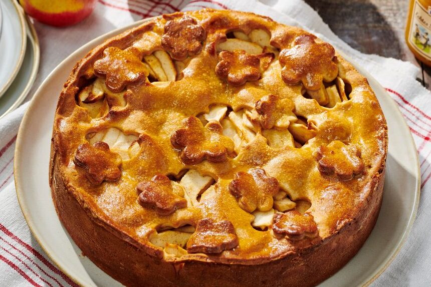 Honing appeltaart op een bord, appels op de achtergrond